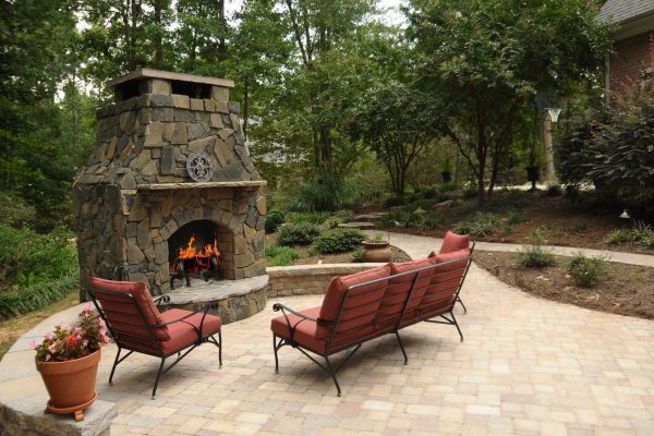 Natural stone patio design with a custom outdoor fireplace in Charlotte