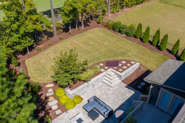 Overview of MetroGreenscape-built backyard with patio, retaining wall, stepping stones, shrubs and privacy trees