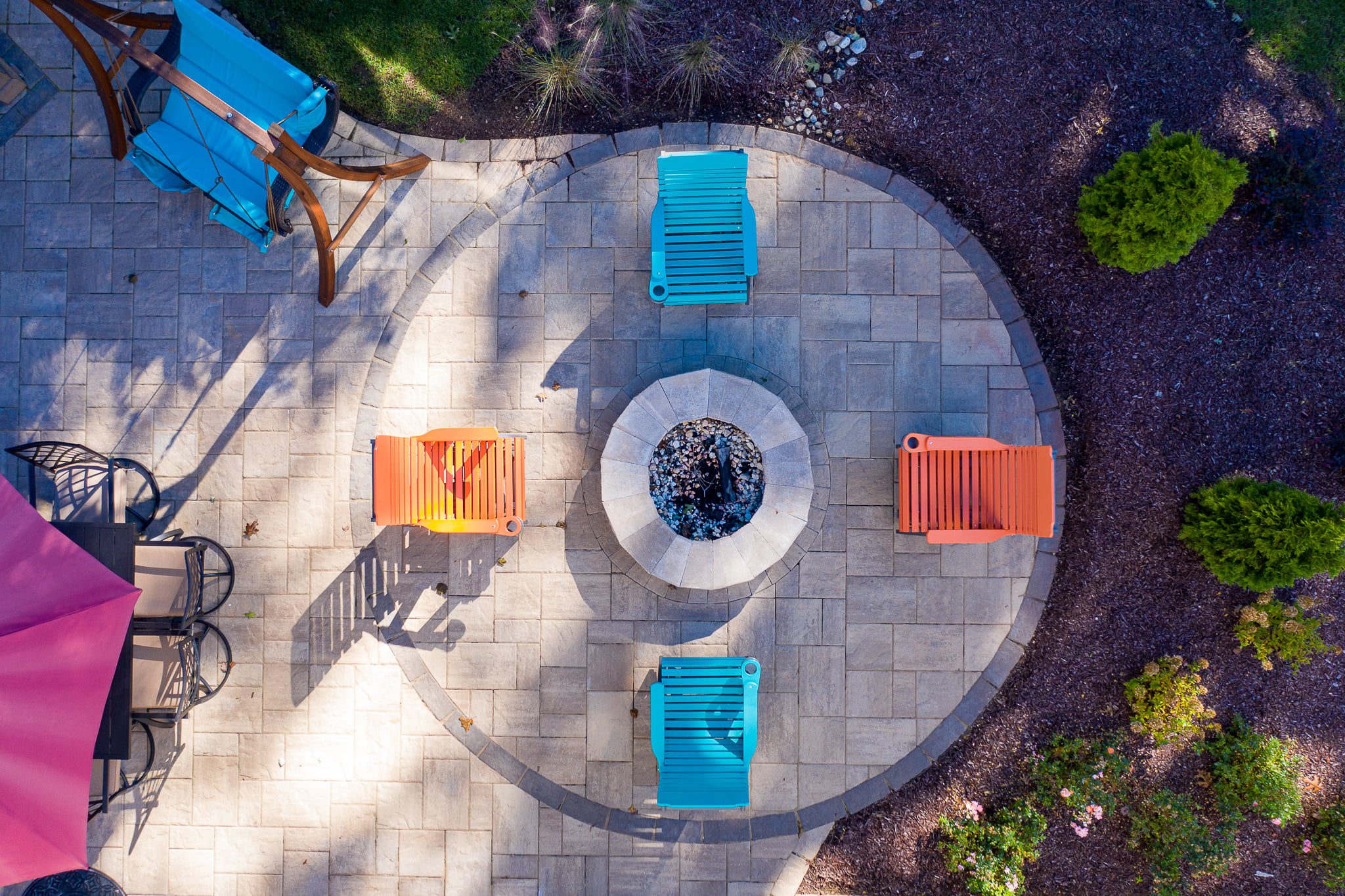 birds-eye view of paver patio and fireplace with colorful outdoor furniture