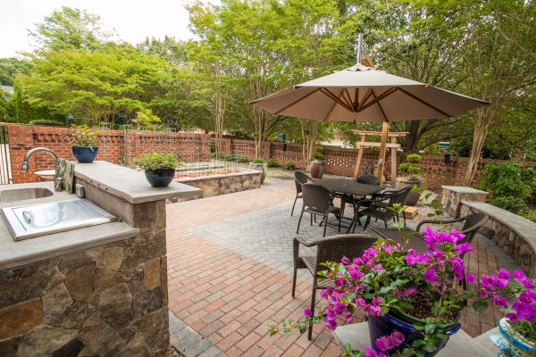 Brick and paver patio with an outdoor kitchen, garden and lawn furniture