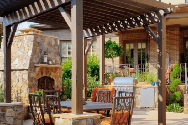 Wooden pergola over a MetroGreenscape custom patio and outdoor kitchen